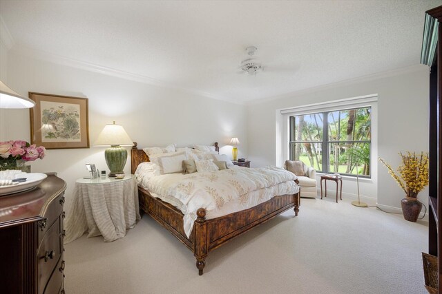 carpeted bedroom with ceiling fan and crown molding