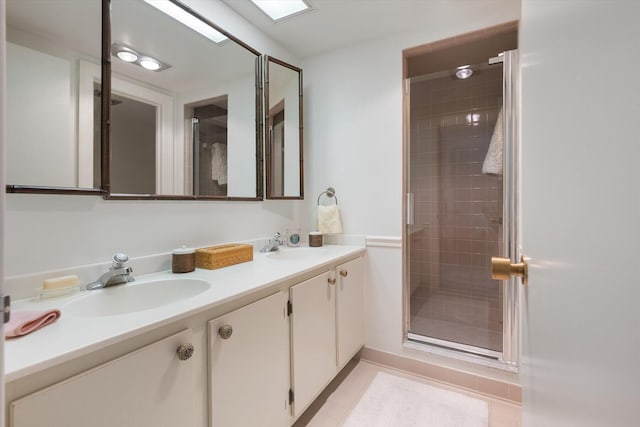 bathroom featuring tile patterned floors, a shower with shower door, and vanity