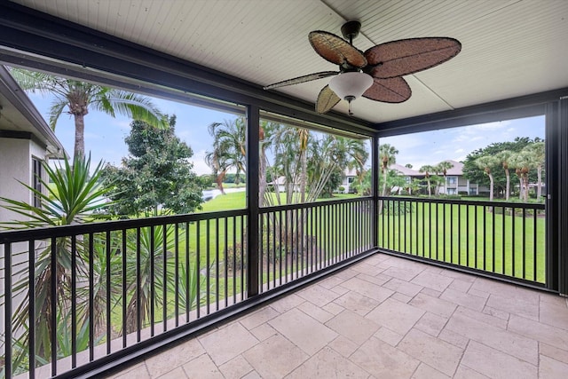 unfurnished sunroom with ceiling fan