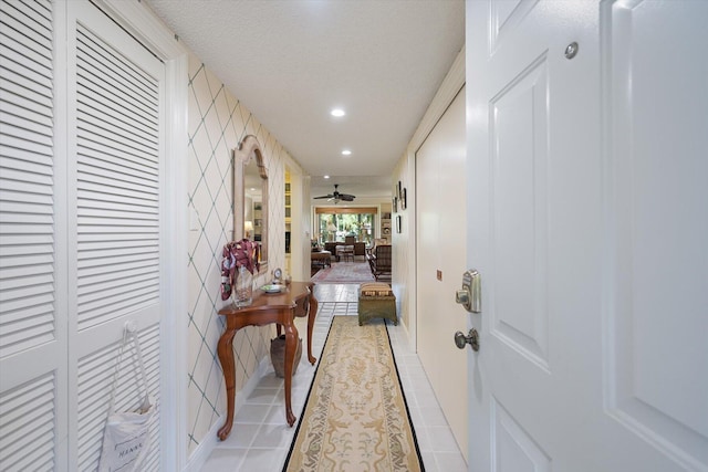 hall featuring a textured ceiling and light tile patterned floors