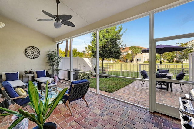 sunroom with ceiling fan and lofted ceiling