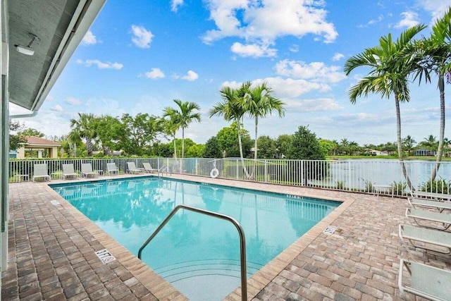 view of pool featuring a water view and a patio area