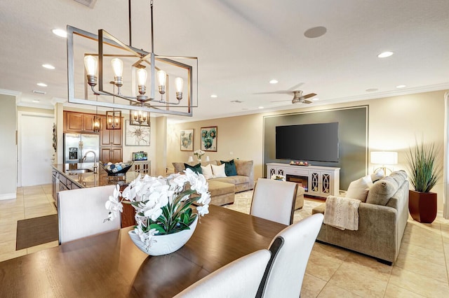 tiled dining area with ceiling fan with notable chandelier, ornamental molding, and sink