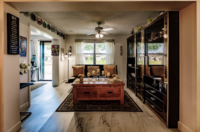 interior space with ceiling fan, a textured ceiling, and light hardwood / wood-style floors