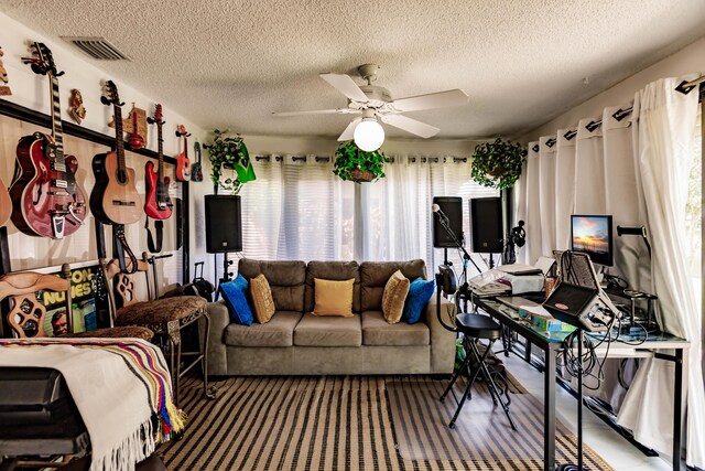 living room with ceiling fan and a textured ceiling