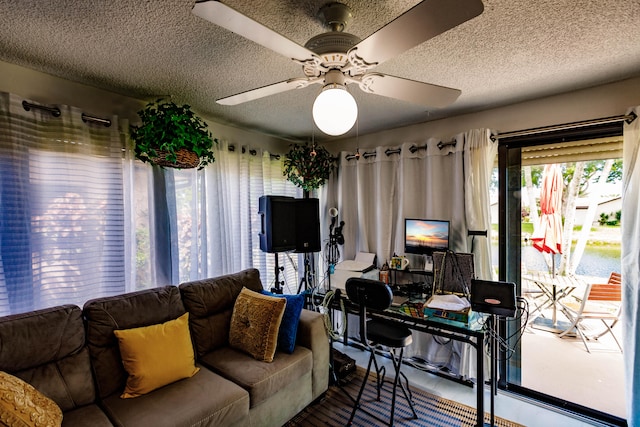 living room with a textured ceiling and ceiling fan