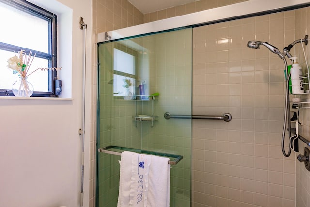 bathroom with a shower with door