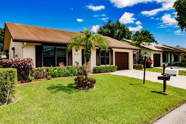 single story home featuring a garage and a front lawn