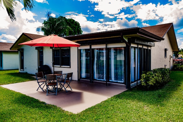 back of house featuring a lawn and a patio area