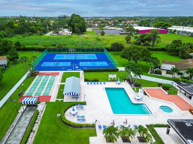 view of swimming pool with a lawn and tennis court