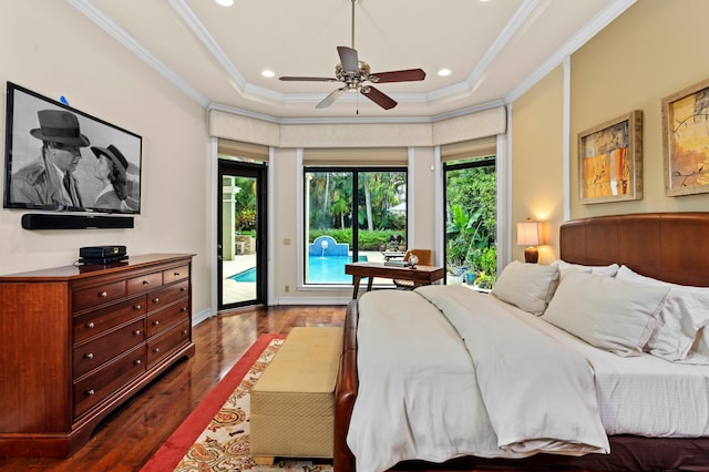 bedroom with ceiling fan, a tray ceiling, dark wood-type flooring, access to exterior, and multiple windows