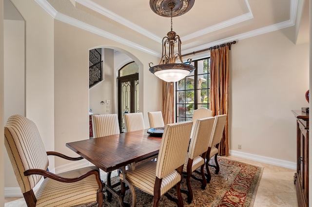 dining area featuring light tile patterned floors, a tray ceiling, and ornamental molding