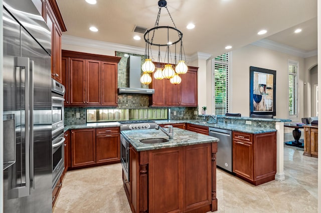 kitchen with decorative light fixtures, a center island with sink, kitchen peninsula, appliances with stainless steel finishes, and wall chimney exhaust hood