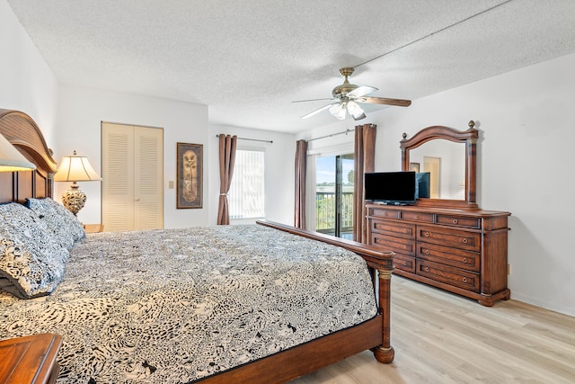 bedroom featuring light wood-type flooring, a textured ceiling, ceiling fan, and a closet