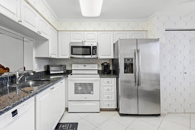 kitchen with stainless steel appliances, white cabinetry, dark stone countertops, and crown molding