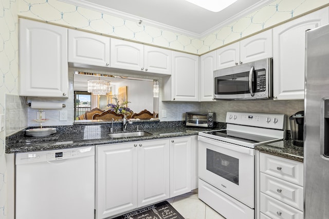 kitchen featuring white cabinets, stainless steel appliances, crown molding, sink, and a chandelier