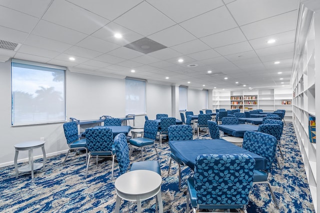 dining space with carpet floors and a drop ceiling