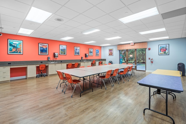 rec room featuring light hardwood / wood-style floors and a drop ceiling