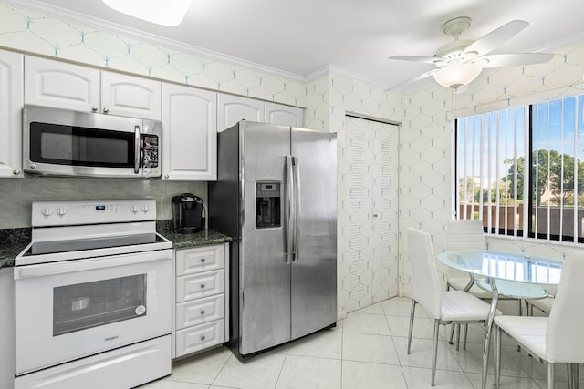 kitchen with ceiling fan, white cabinets, stainless steel appliances, and ornamental molding