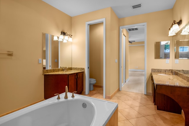 bathroom featuring vanity, toilet, tile patterned floors, and a washtub