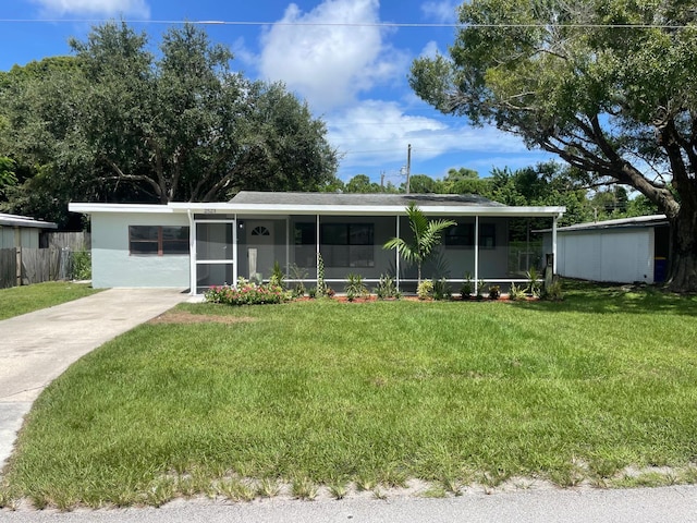 view of front of property featuring a front yard and a sunroom