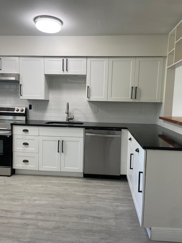 kitchen with light wood-type flooring, appliances with stainless steel finishes, white cabinetry, and sink