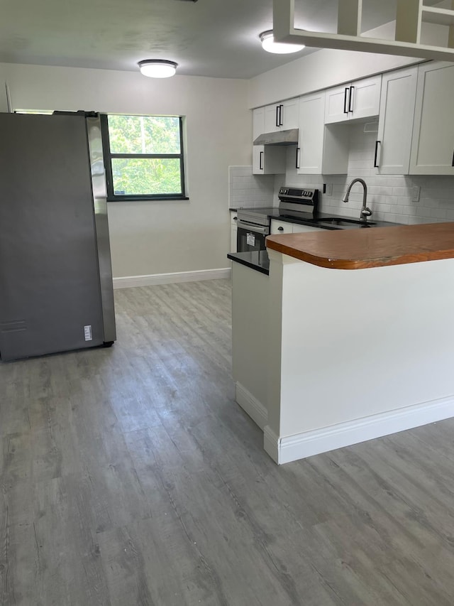 kitchen featuring light wood-type flooring, butcher block countertops, sink, appliances with stainless steel finishes, and white cabinets