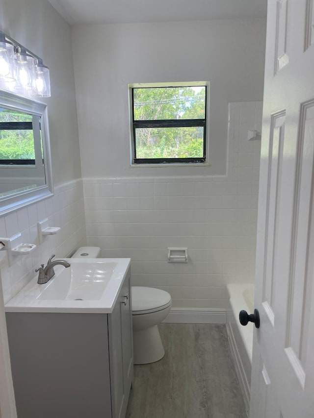 full bathroom featuring vanity, toilet, tile walls, and wood-type flooring