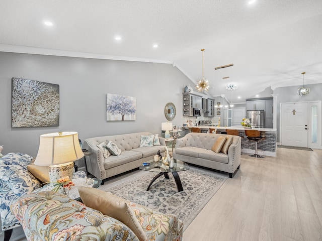 living room featuring lofted ceiling, a notable chandelier, light hardwood / wood-style floors, and crown molding