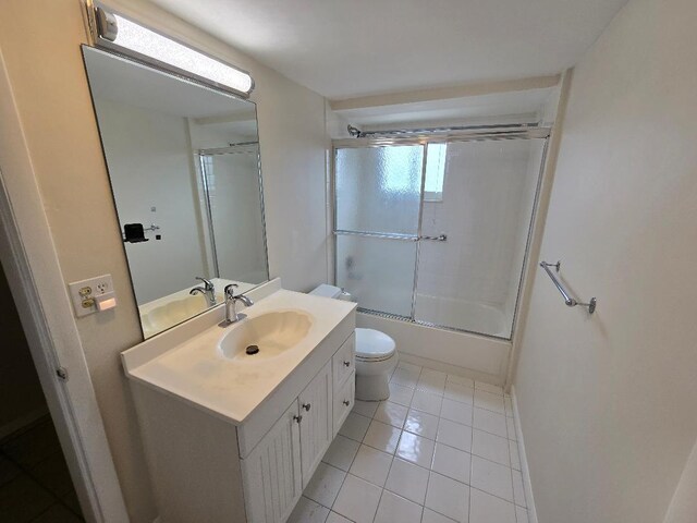 full bathroom with vanity, toilet, tile patterned floors, and bath / shower combo with glass door