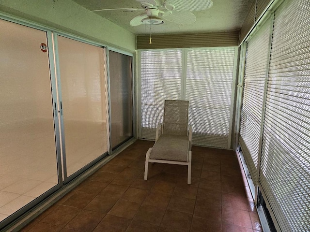 unfurnished sunroom featuring ceiling fan