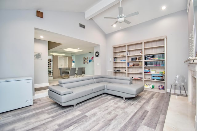 living room featuring beamed ceiling, high vaulted ceiling, a high end fireplace, wood-type flooring, and ceiling fan