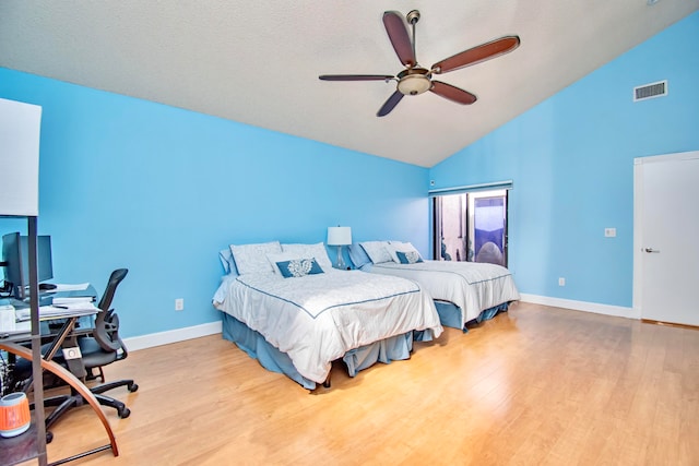 bedroom featuring a textured ceiling, light hardwood / wood-style flooring, ceiling fan, and high vaulted ceiling