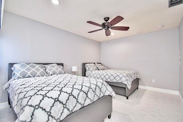 bedroom featuring a textured ceiling, light tile patterned floors, and ceiling fan