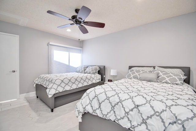 bedroom with tile patterned floors, ceiling fan, and a textured ceiling