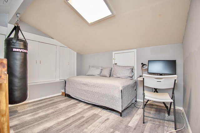 bedroom featuring lofted ceiling and light hardwood / wood-style flooring