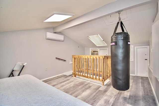 bedroom featuring a wall unit AC, hardwood / wood-style flooring, and lofted ceiling with beams