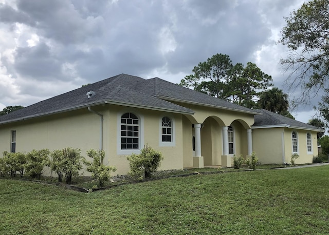 single story home featuring stucco siding and a front lawn