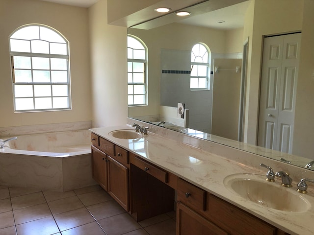 bathroom featuring plus walk in shower, tile patterned flooring, and vanity