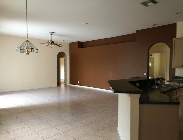 kitchen featuring hanging light fixtures, ceiling fan, sink, and light tile patterned floors