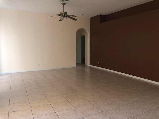 tiled spare room featuring ceiling fan