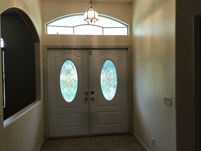 entryway featuring french doors, light tile patterned flooring, and a healthy amount of sunlight