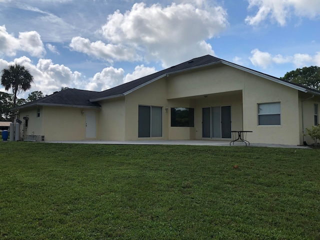 back of property featuring a lawn and a patio