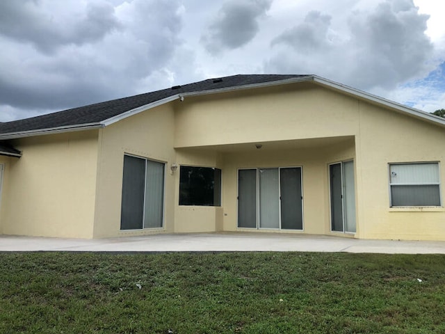 rear view of house with a yard and a patio area