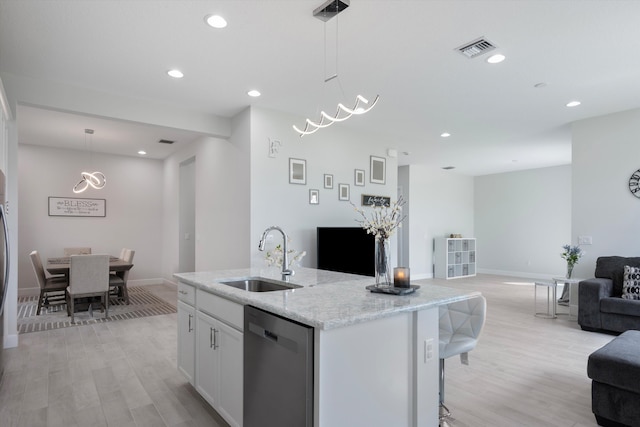 kitchen featuring pendant lighting, light wood-type flooring, dishwasher, sink, and white cabinets