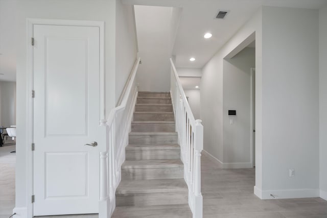 stairs featuring hardwood / wood-style floors