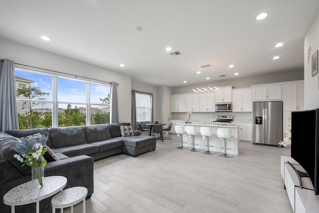 living room featuring light hardwood / wood-style floors and sink