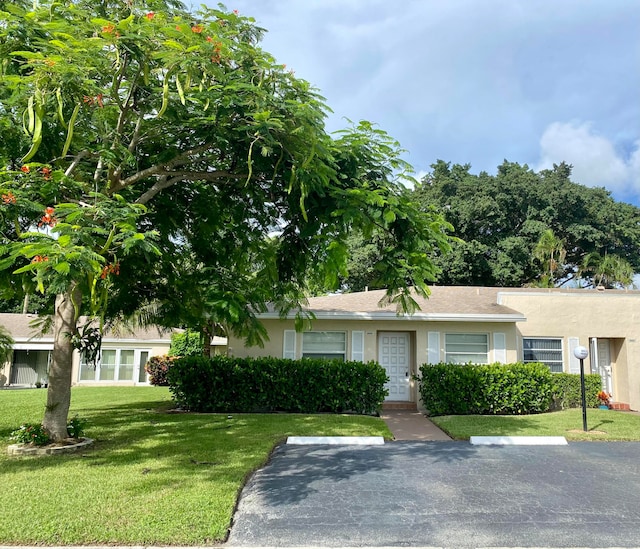 single story home with a front lawn