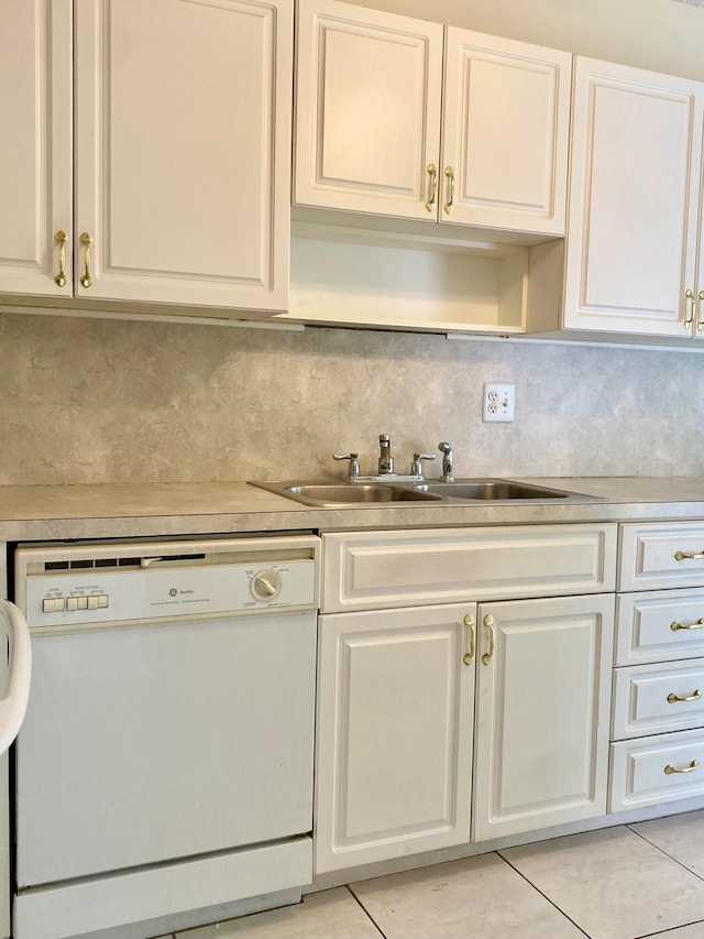 kitchen with dishwasher, backsplash, sink, white cabinets, and light tile patterned flooring