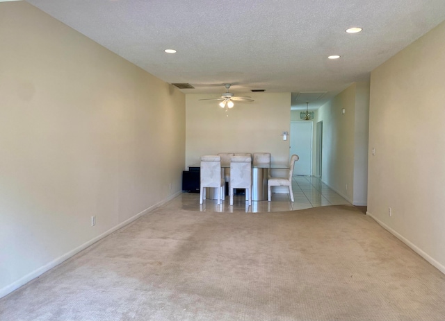 interior space featuring light colored carpet, a textured ceiling, and ceiling fan